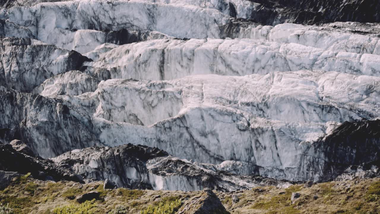 一名男子沿着冰川旁的山脊徒步旅行视频素材