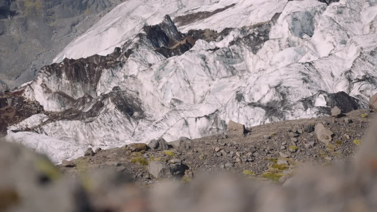 旅行者携带吉他盒在岩石山旁边的冰川视频素材