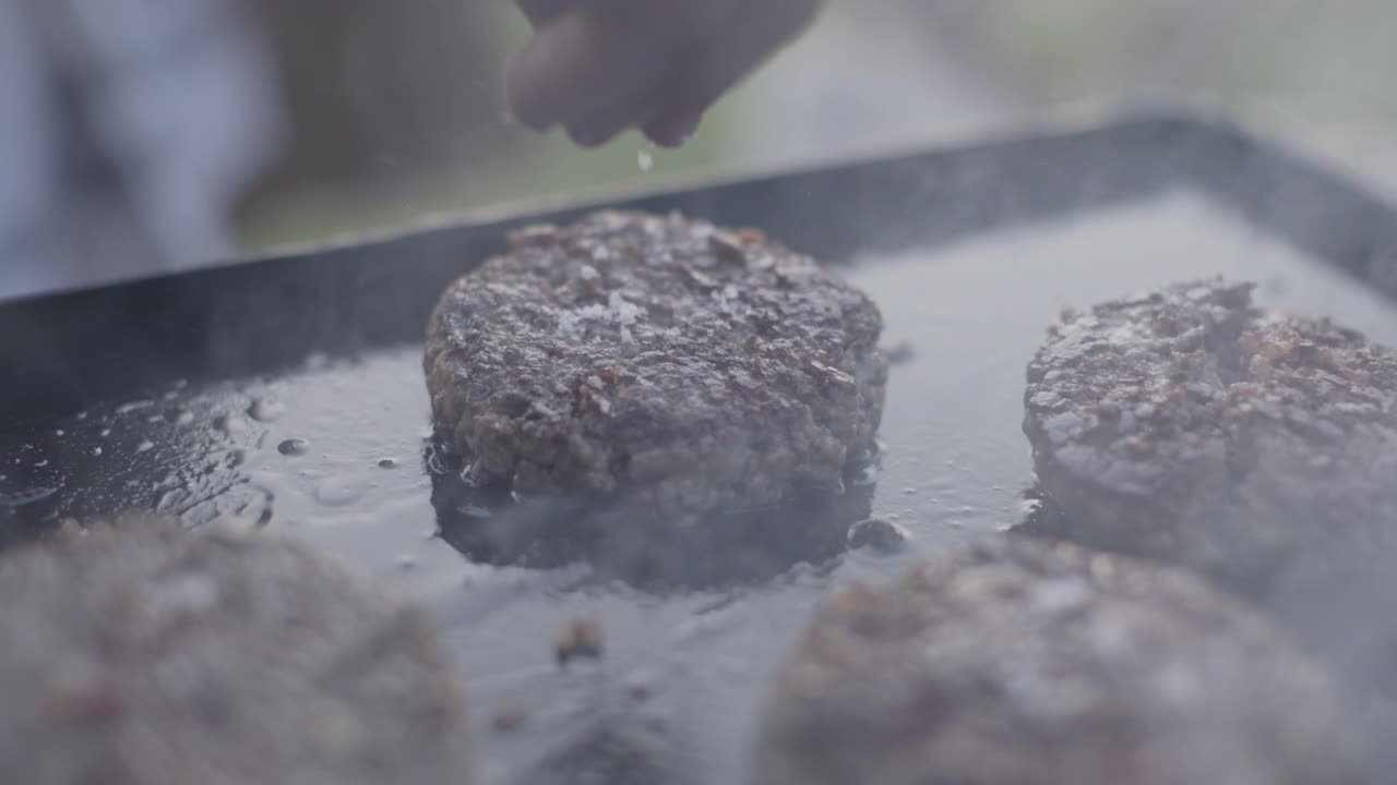 把盐放在汉堡肉饼上视频素材