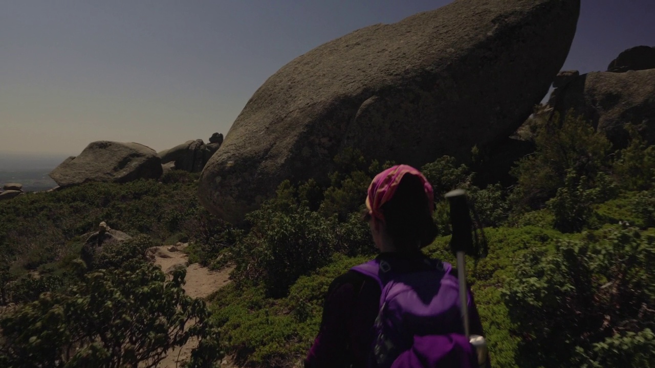 跟踪拍摄的女子在山上徒步旅行。视频素材