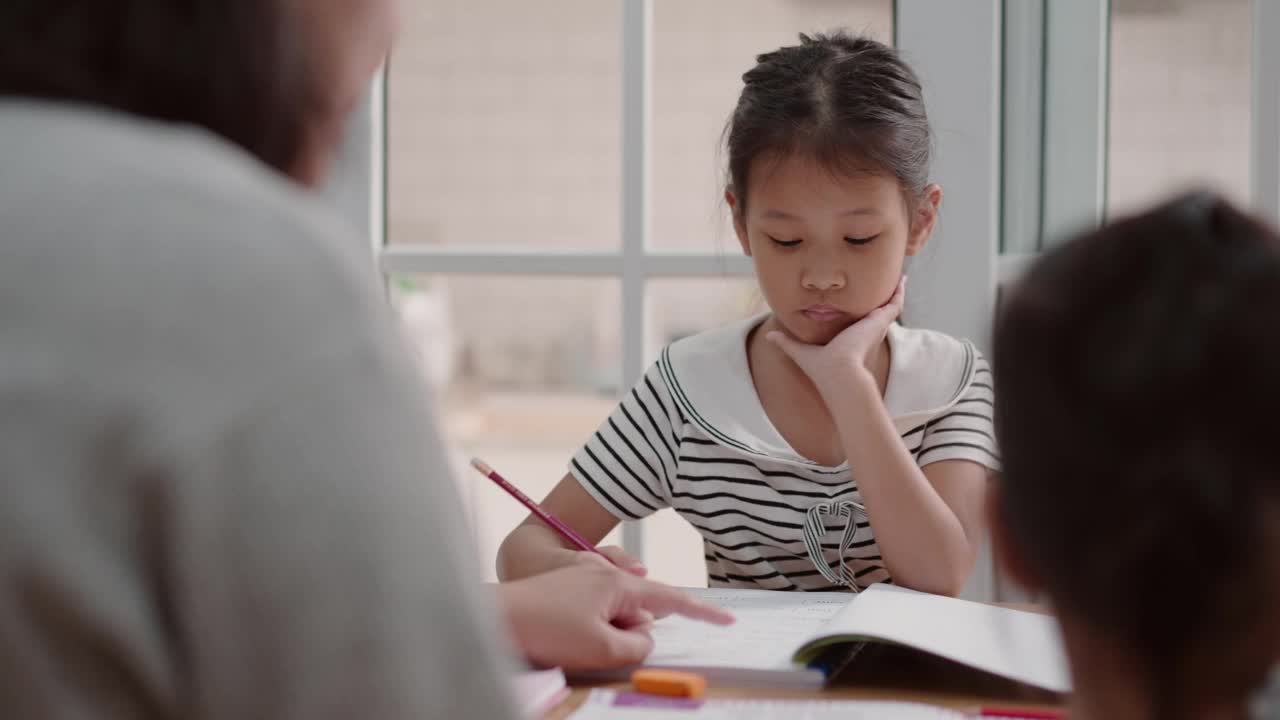 母亲照顾两个女儿在家学习，照顾姐姐视频素材