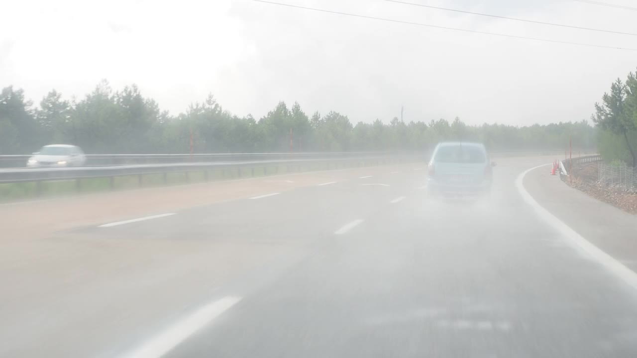 汽车视角驾驶，汽车行驶在潮湿和下雨的公路上视频素材