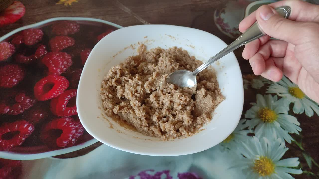 视频中，一名男子正在搅拌荞麦粥视频素材