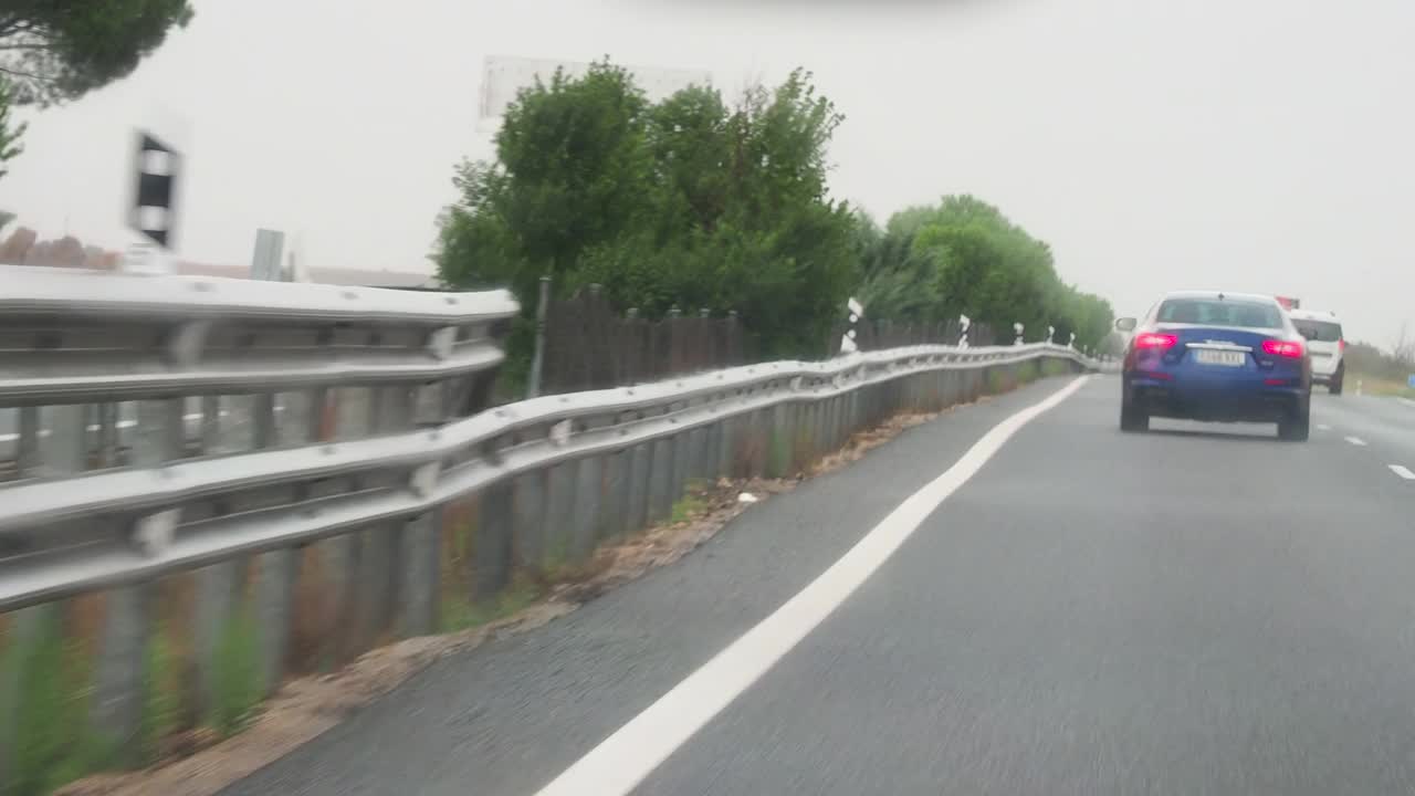 车的角度驾驶，汽车经过一个潮湿和下雨的道路视频素材