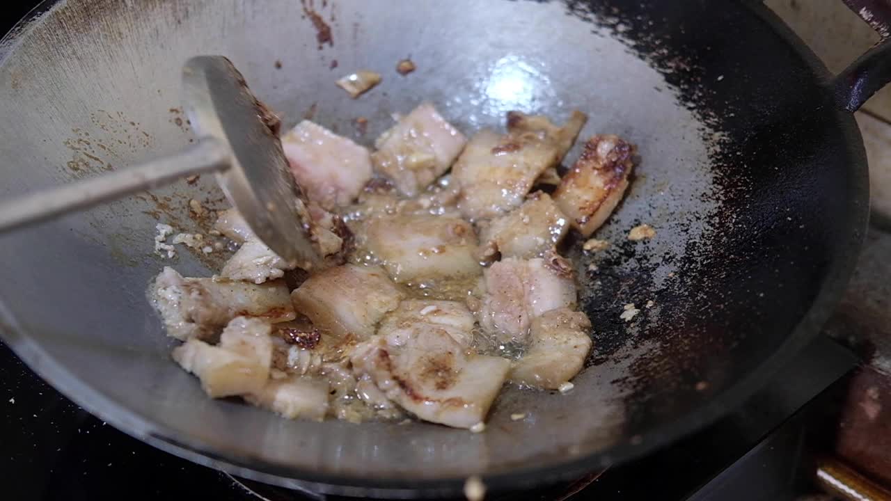 用热锅煎蒜头和辣椒炒五花肉视频素材