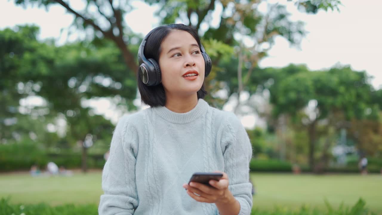 亚洲女人用耳机听音乐视频素材