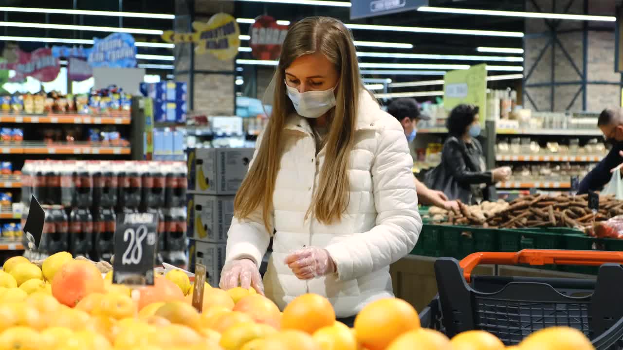 女孩在超市买柠檬、柑橘、健康食品。视频素材