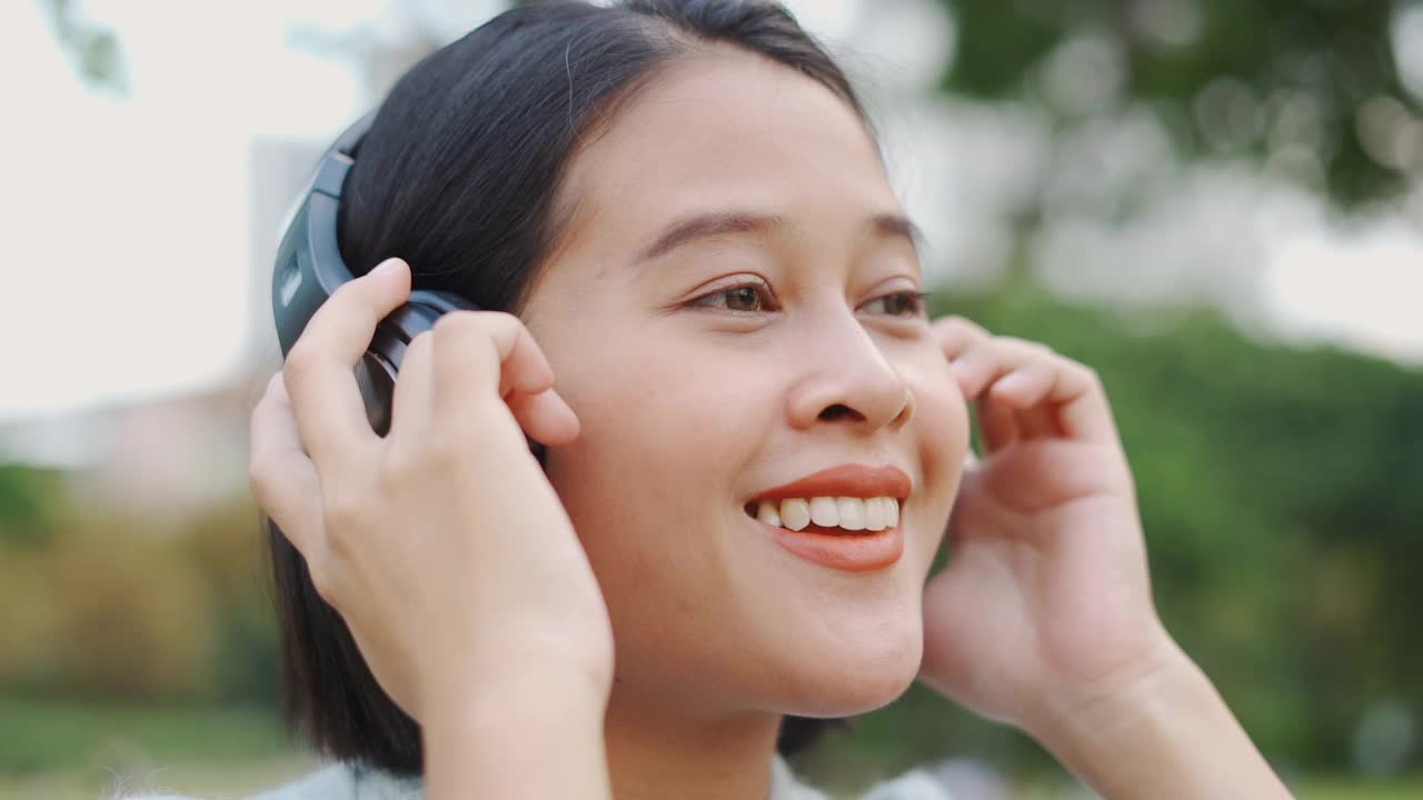 亚洲女人用耳机听音乐视频素材