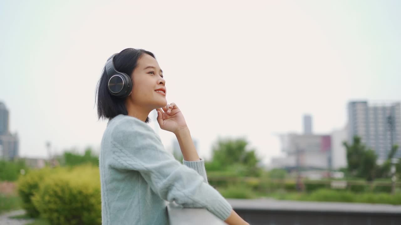 亚洲女人用耳机听音乐视频素材