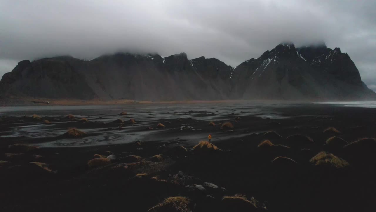 无人机拍摄到一个人在冰岛海岸线中部有着引人注目的火山景观。视频素材