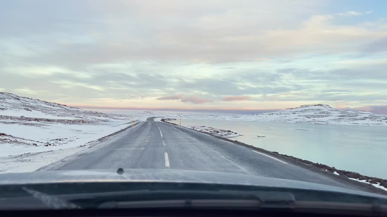 在冰岛的公路旅行中，早上行驶在结冰的道路上。视频素材