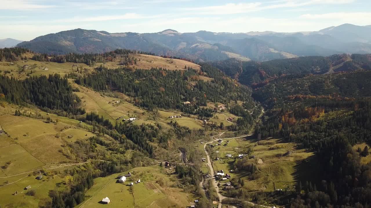 鸟瞰秋天的山景常绿的松树和黄色的秋天森林与雄伟的山脉在远处。视频素材