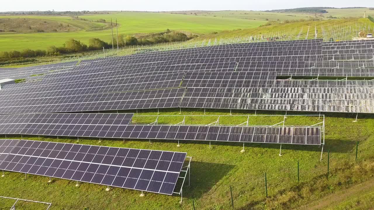 绿地上正在建设的太阳能发电厂鸟瞰图。生产清洁生态能源的电板组装。视频素材