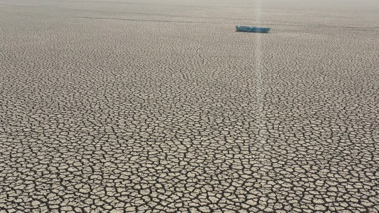 航拍的一艘渔船在干涸的湖床上。视频素材