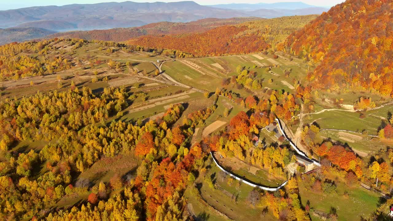 村庄的田野、房屋和山峰的秋景被阳光照亮视频素材