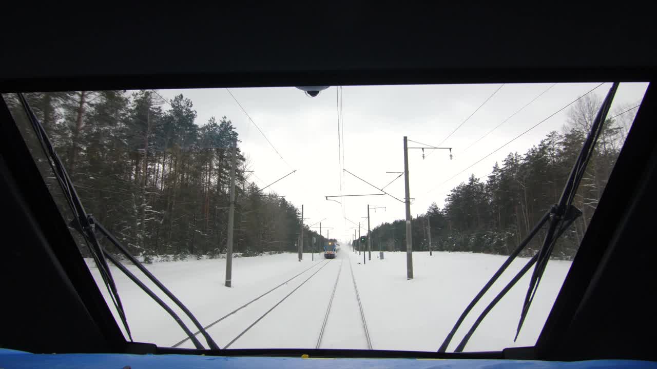 城际现代电动火车行驶在积雪覆盖的铁轨上视频素材