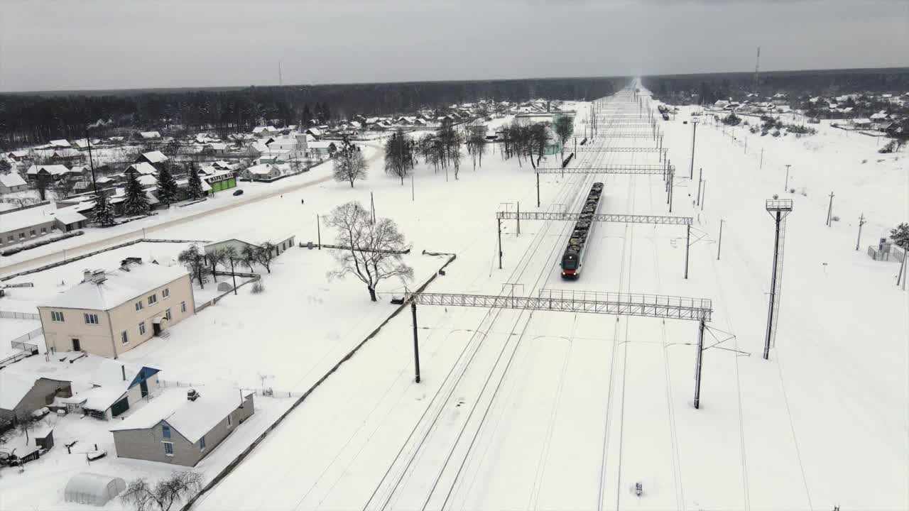 城际现代电动火车行驶在积雪覆盖的铁轨上视频素材