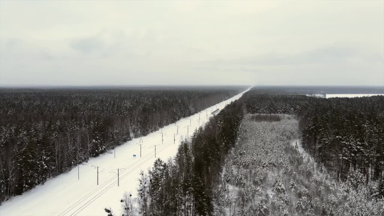 城际现代电动火车行驶在积雪覆盖的铁轨上视频素材