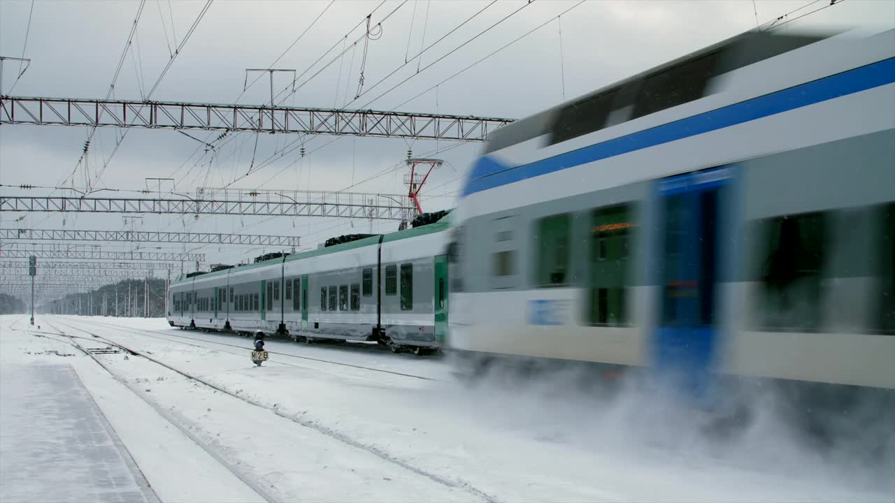 城际现代电动火车行驶在积雪覆盖的铁轨上视频素材