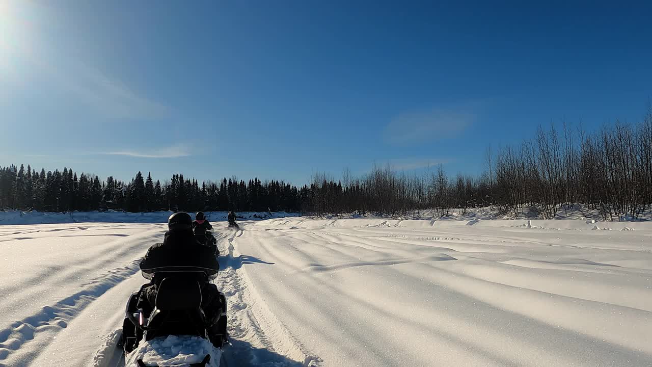 两辆雪地车在松林中的慢镜头。视频素材