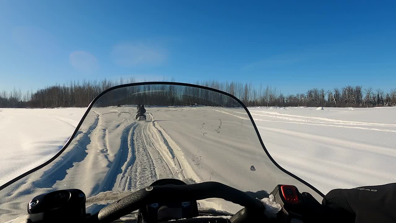 雪地摩托骑过松林的慢镜头的POV视图视频素材