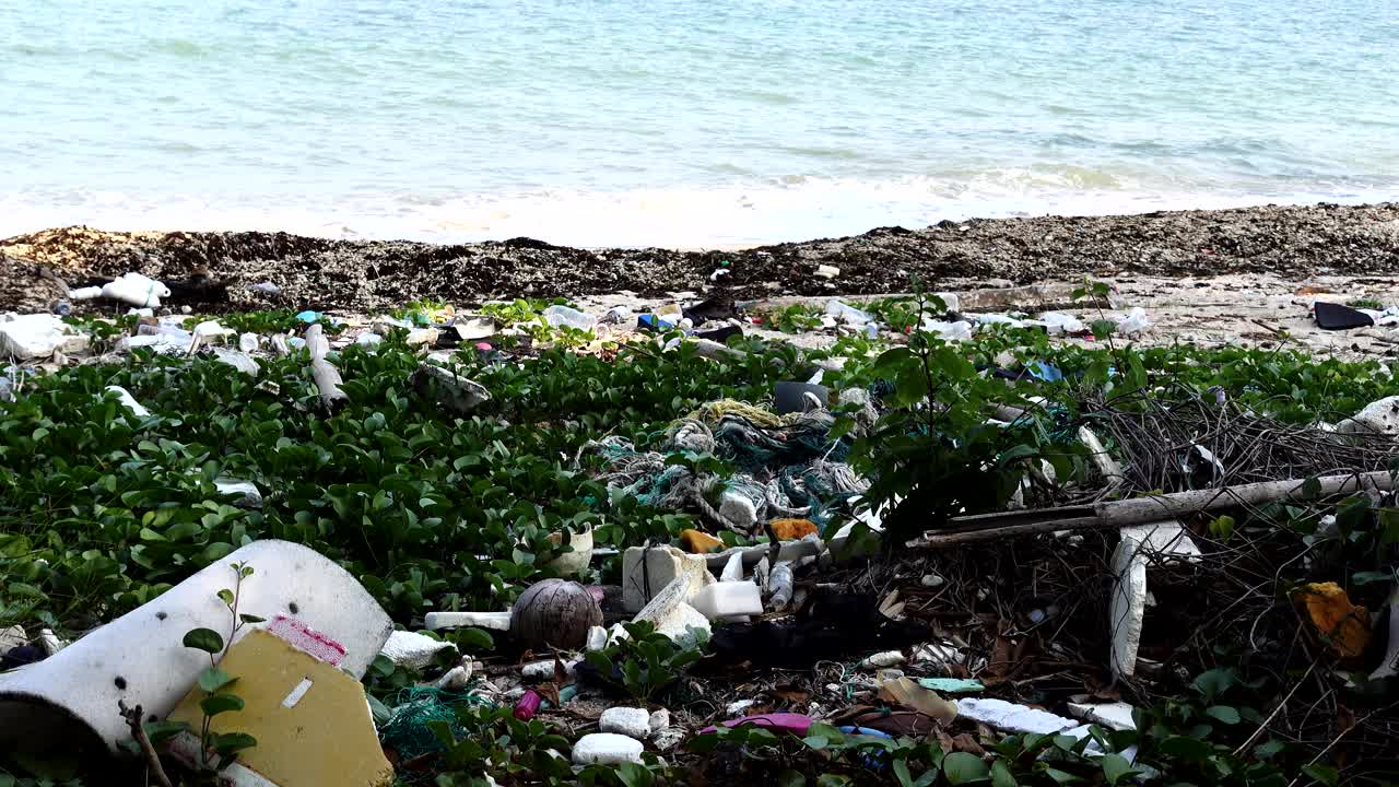 被污染的海滩景观，满是垃圾和大海的背景视频素材