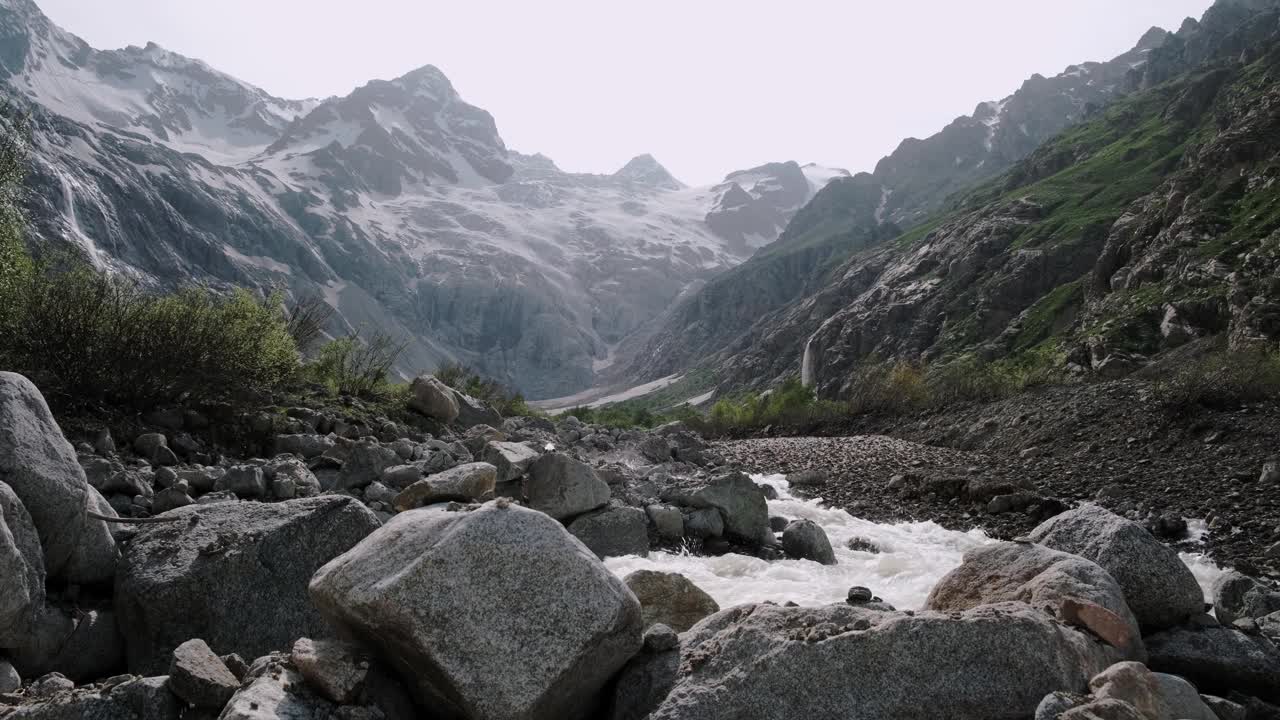 湍急的山河在岩石间流动。山上的雪和冰川视频素材