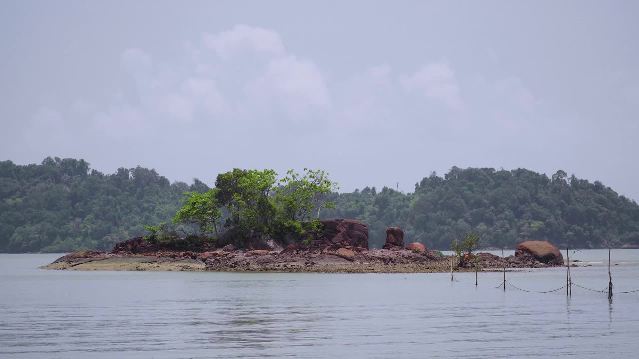 小热带岛屿与树木和岩石在海和多云蓝天的背景。恩多海滩景观，马来西亚视频素材