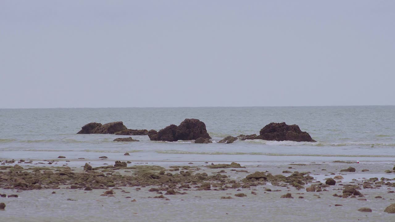 多岩石的海滩和海浪撞击岩石或海石，形成浪花的时间流逝的海景。Endau、马来西亚视频素材