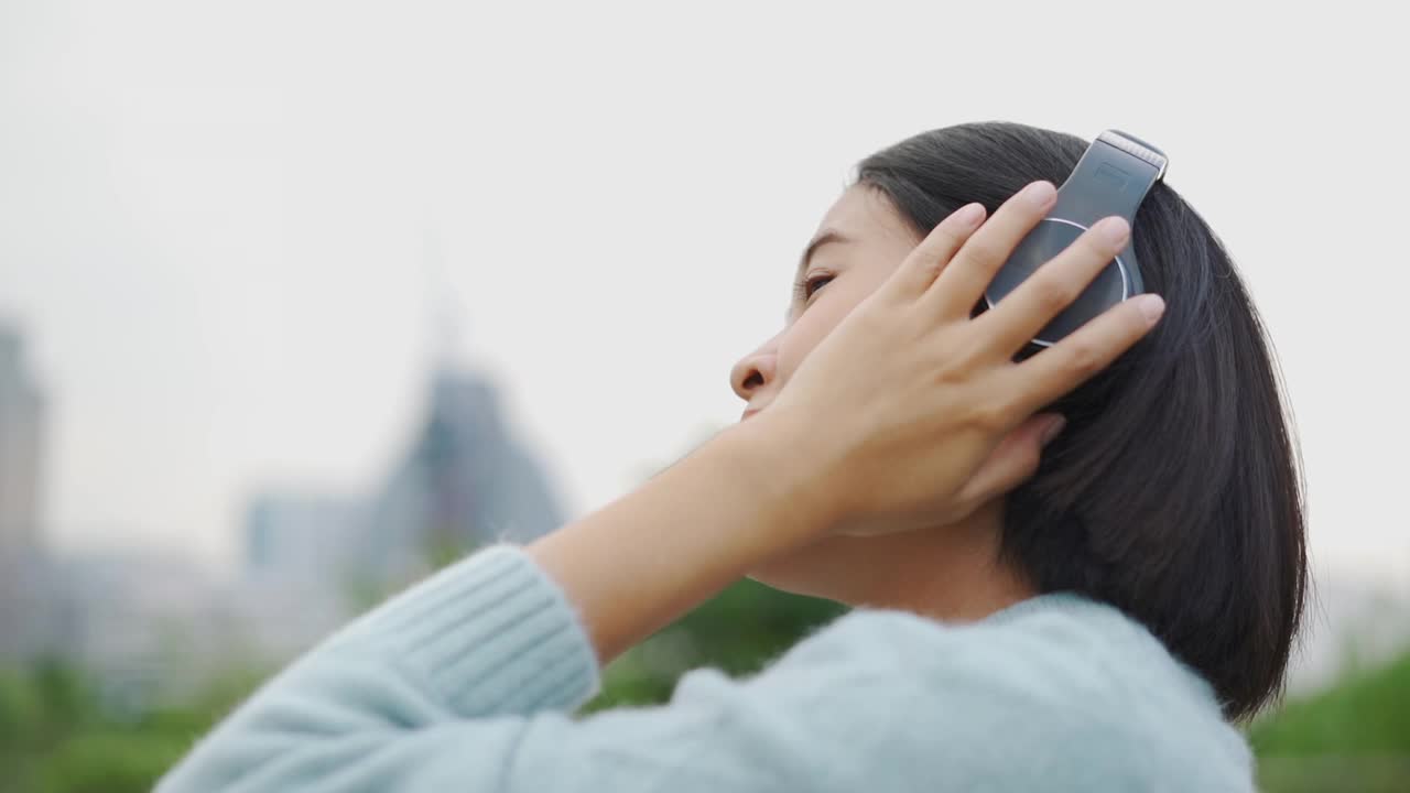 亚洲女人用耳机听音乐视频素材