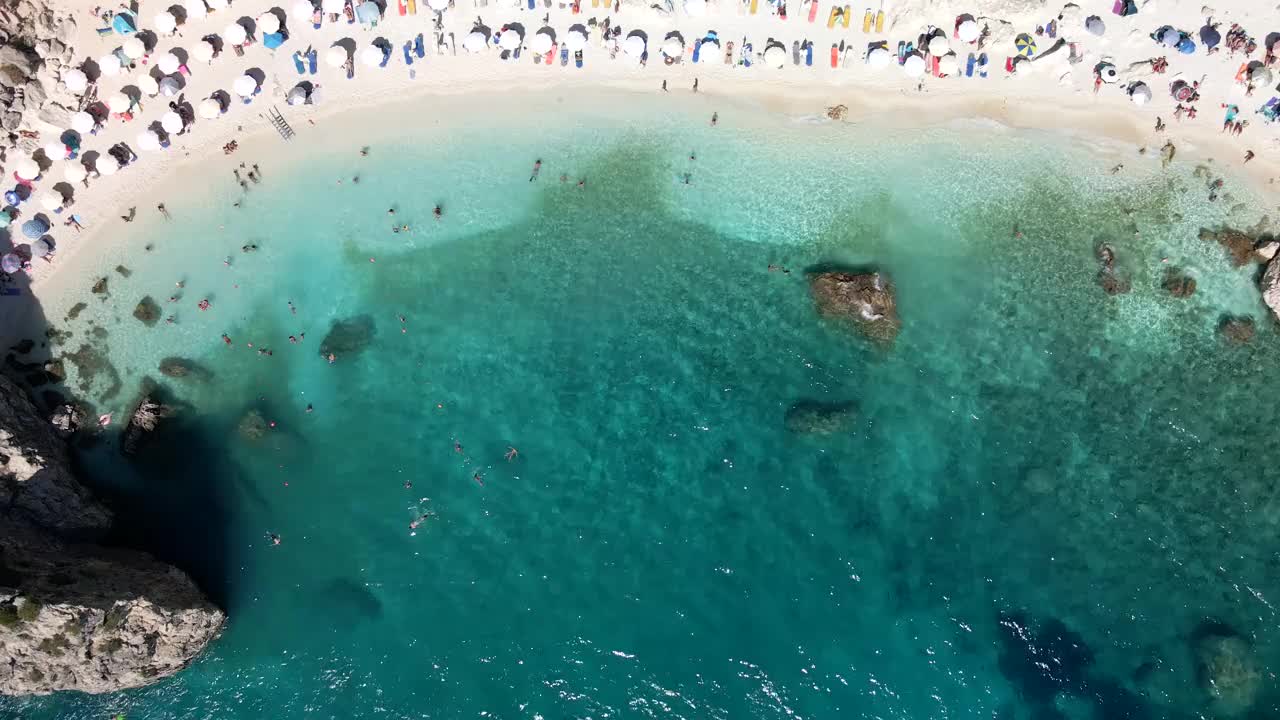 鸟瞰图的莱夫卡斯海滩在阳光明媚的夏天，人们在希腊度假日光浴视频素材