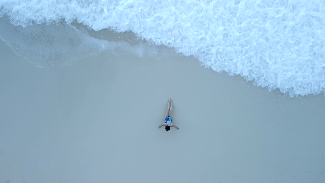 在海滩上穿泳衣的女人的俯视图视频素材