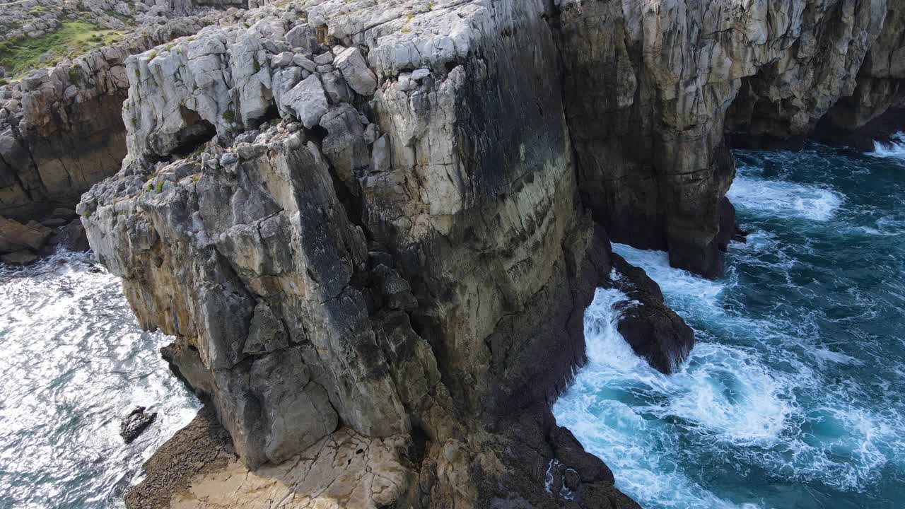 鸟瞰图的波浪打破岩石在蓝色的海洋。鸟瞰图的海浪撞击岩石悬崖。高质量4k素材视频素材