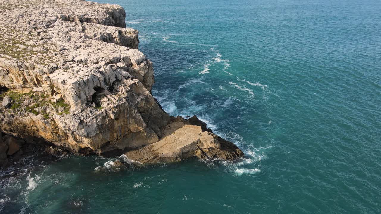 鸟瞰图的波浪打破岩石在蓝色的海洋。鸟瞰图的海浪撞击岩石悬崖。高质量4k素材视频素材