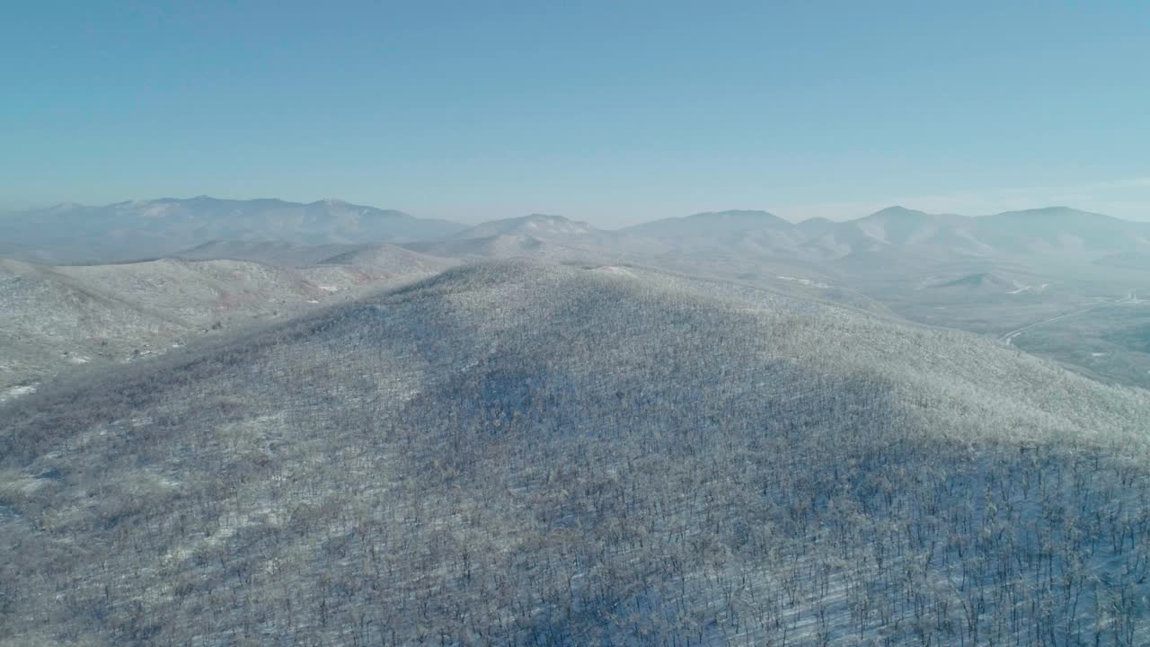 空中冬季山景的冰冻森林与雪和冰覆盖的树木在阳光明媚的冬天的一天。飞越冬季森林。相机移动离开视频素材