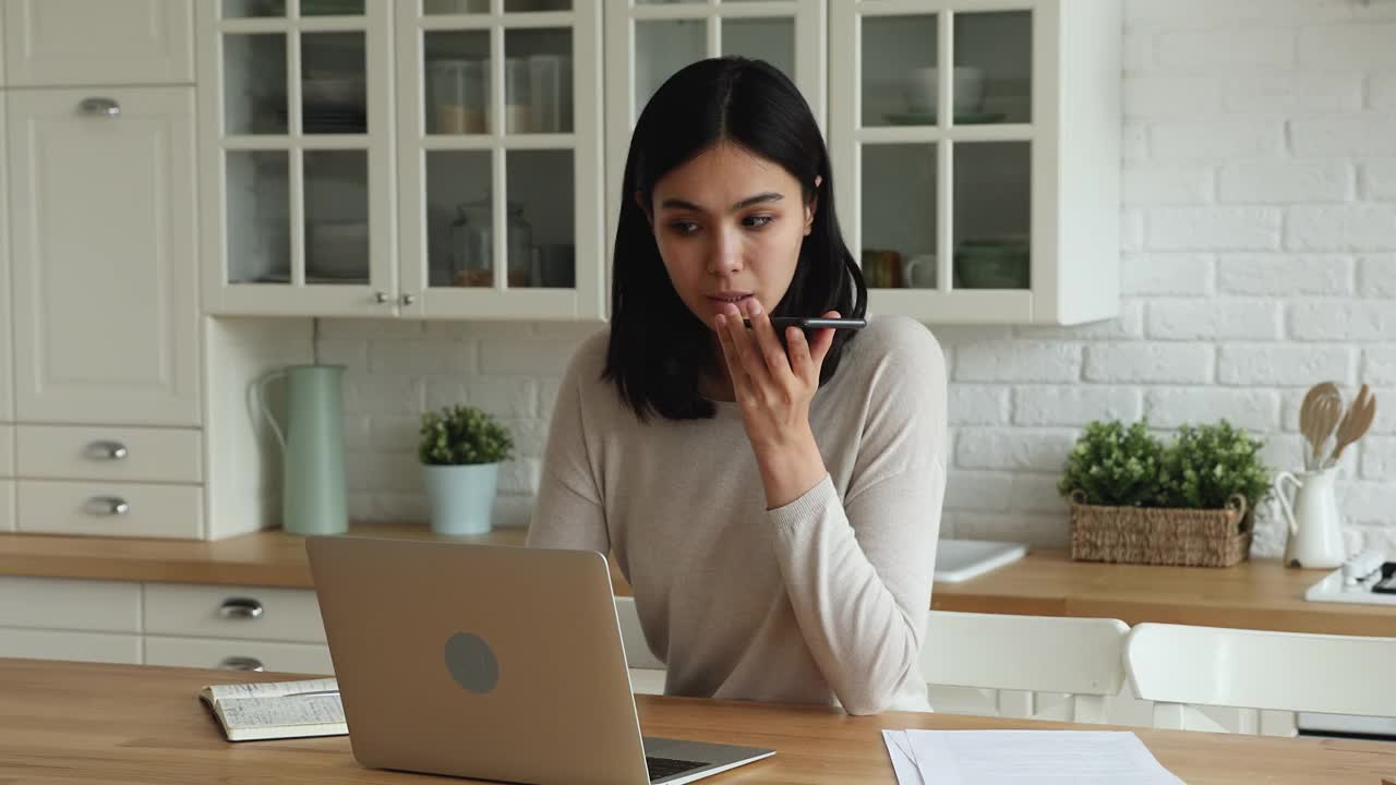 专注的年轻亚洲妇女录音信息。视频素材