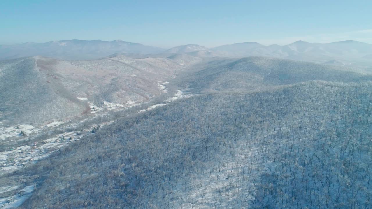 空中冬季山景的冰冻森林与雪和冰覆盖的树木在阳光明媚的冬天的一天。飞越冬季森林。镜头推进视频素材