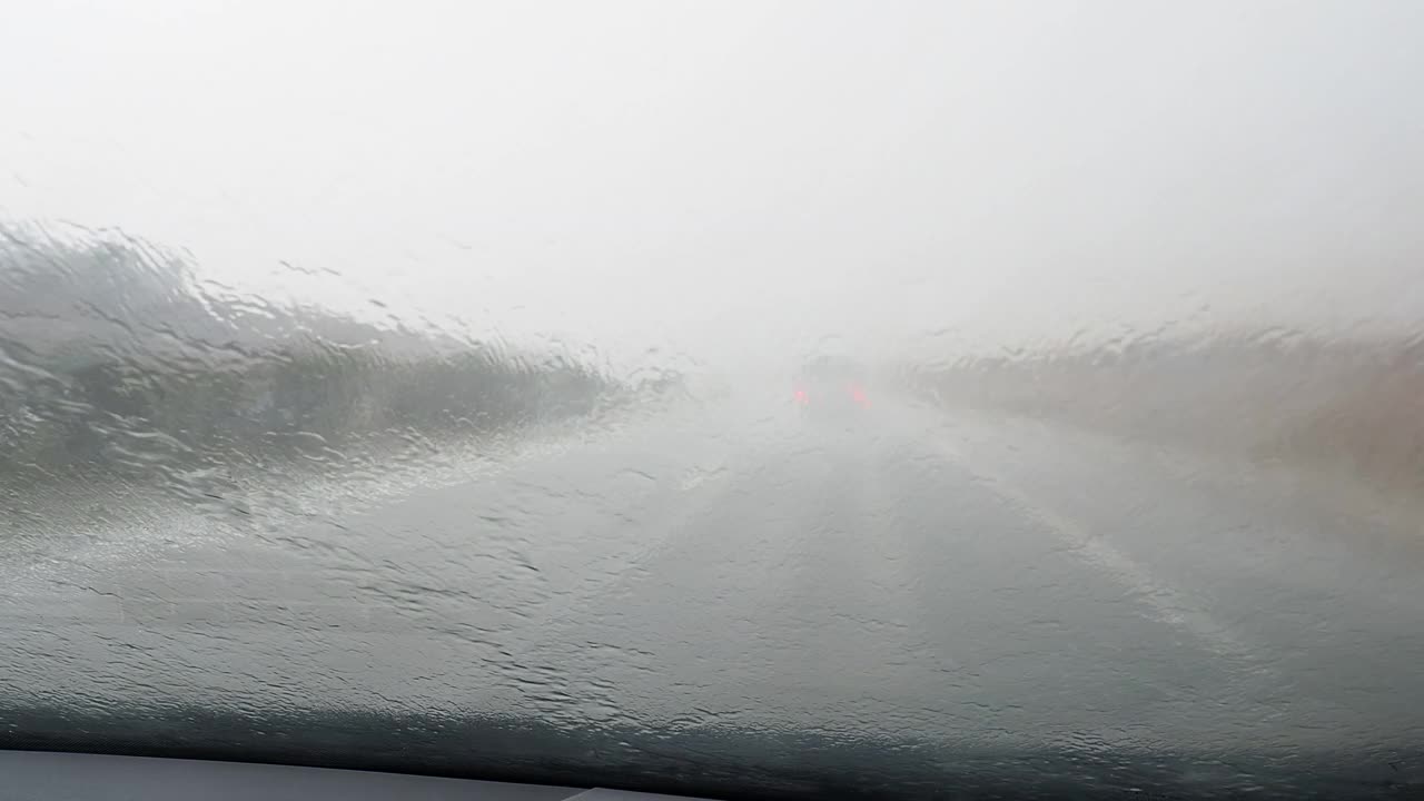 车的观点行驶在下雨的公路和挡风玻璃雨刷擦雨视频素材