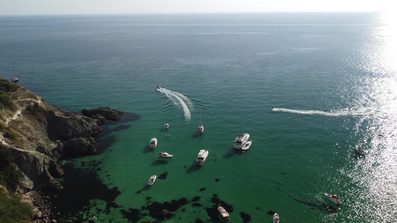 鸟瞰海景与清澈蔚蓝的大海和岩石海岸。游艇在岩石背景下美丽的泻湖上。夏季旅游和度假的理想目的地的概念视频素材