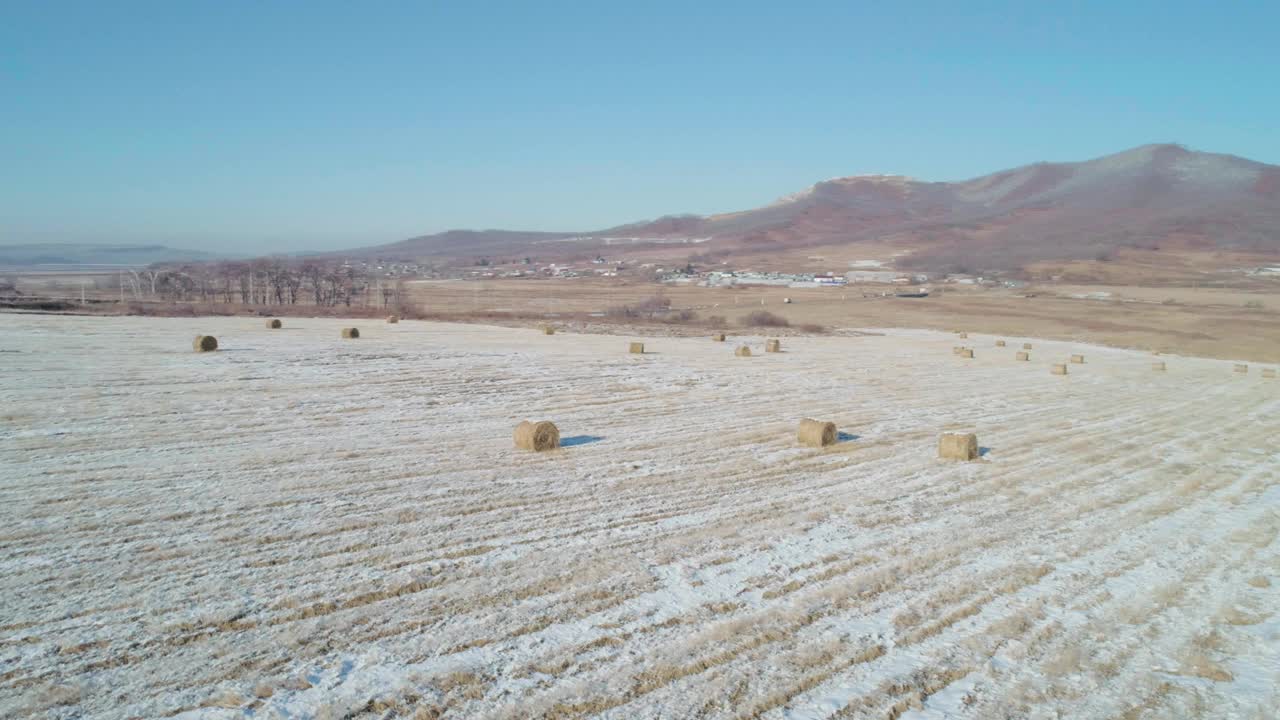 空中轨道景观的干草，覆盖着雪和冰冻的森林和山脉在冬季的背景视频素材