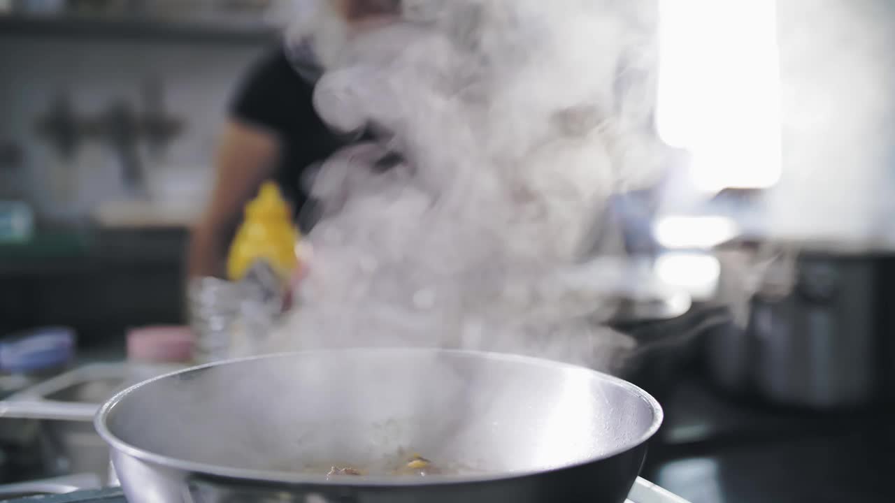 烹饪。热气腾腾的食物。自助餐厅的厨房。特写镜头。食物在锅里冒着热气，沸腾着。在商业厨房准备和烹饪食物视频素材