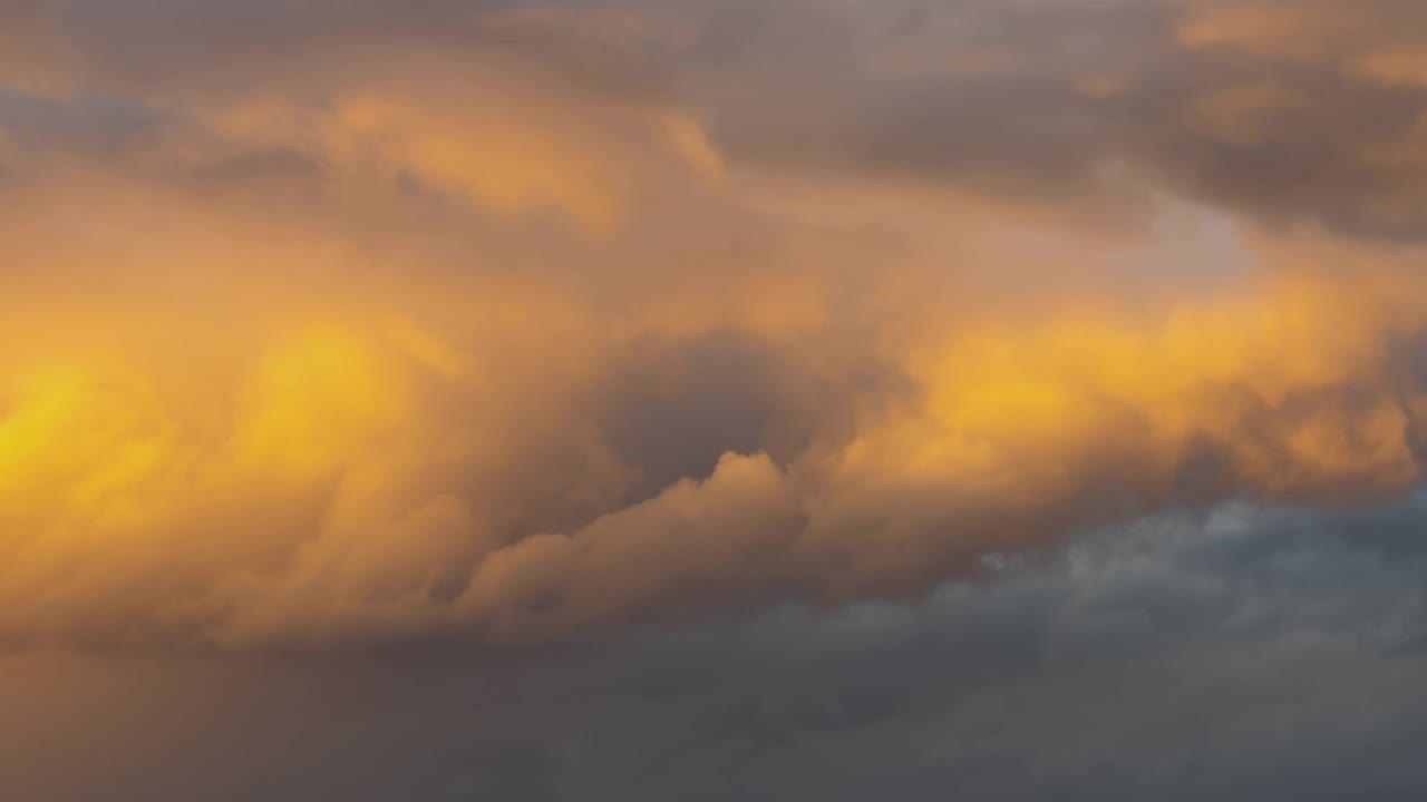 日落时，暗黄色天空上快速移动的暴风雨云的时间流逝。视频素材