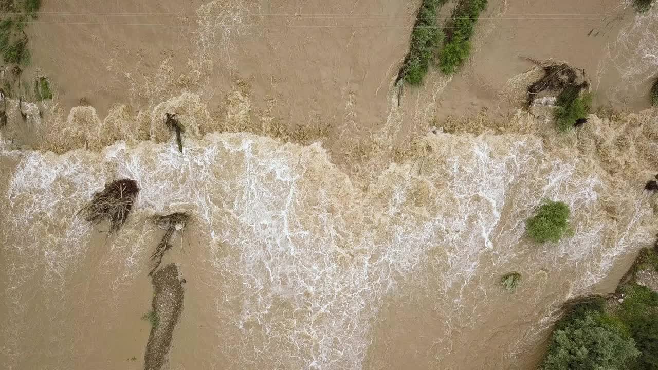 鸟瞰图宽阔的肮脏的河流与泥泞的水在洪水期间在暴雨的春天。视频素材