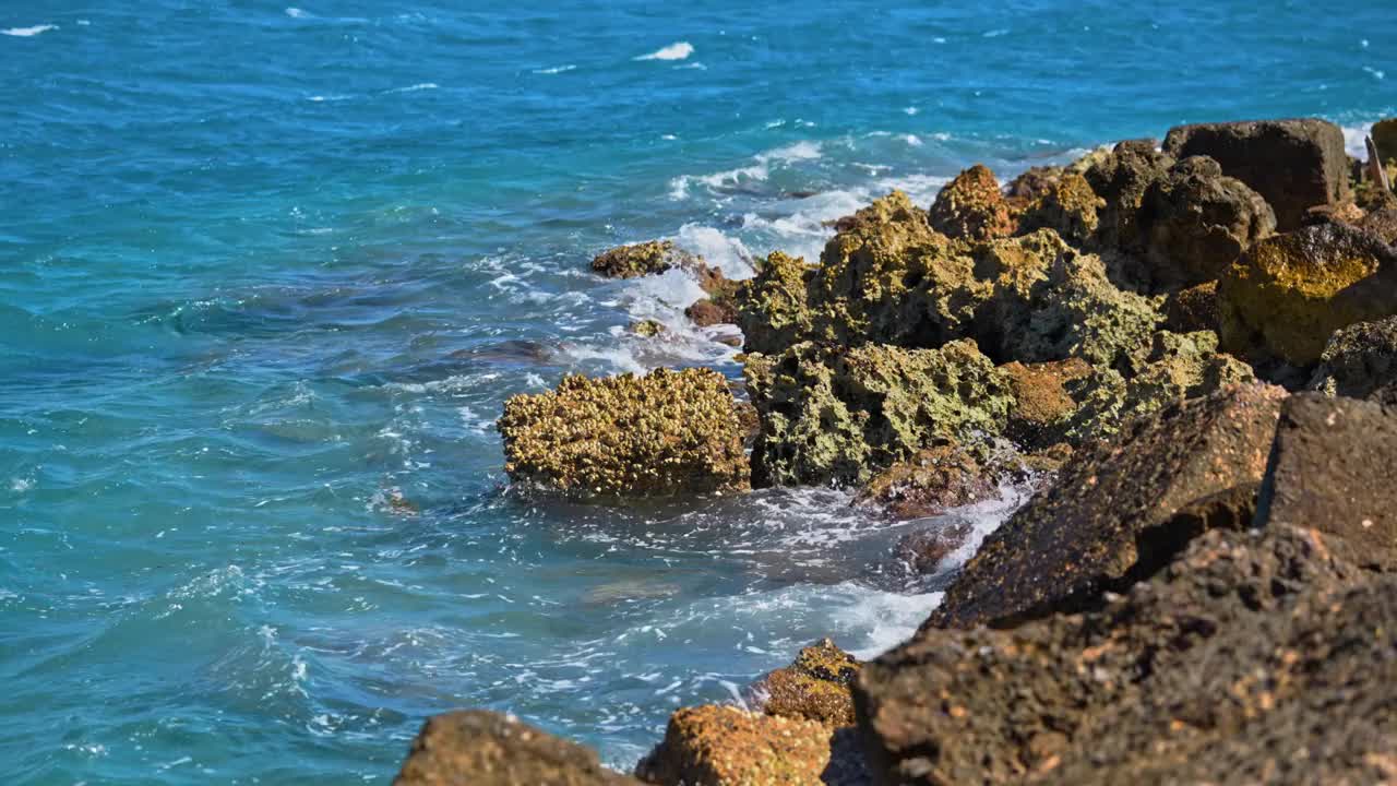 强烈的海浪拍打着岩石的海滩视频素材