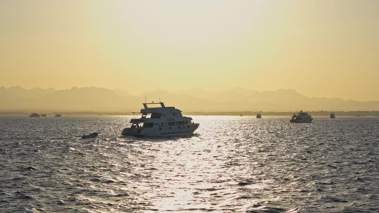 鸟瞰美丽的白色帆船在蓝色的大海在明亮的阳光夏夜。克罗地亚的亚得里亚海。风景有游艇，山，透明的蓝色的水，日落的天空。船的俯视图视频素材