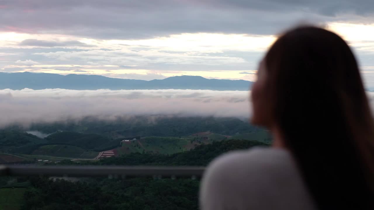 模糊的背面的女性旅行者看一个美丽的山景在雾天视频素材