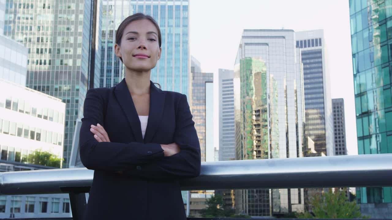 亚洲的女商人。自信严肃的商界女性肖像。中国专业人士身着黑色西装，在城市背景下，市中心的人们生活方式。交叉双臂的自信女士。视频素材