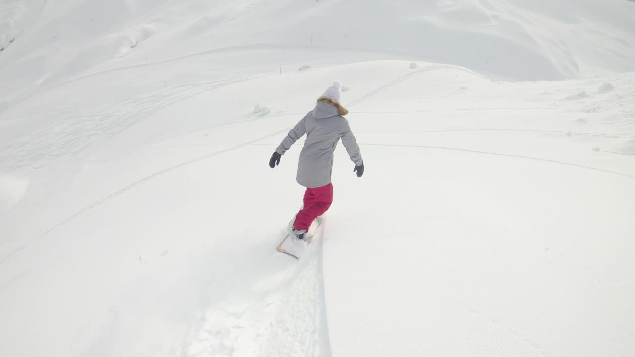 慢动作:女人用滑雪板横穿整个国家，撕碎刚刚撒下的雪。视频素材