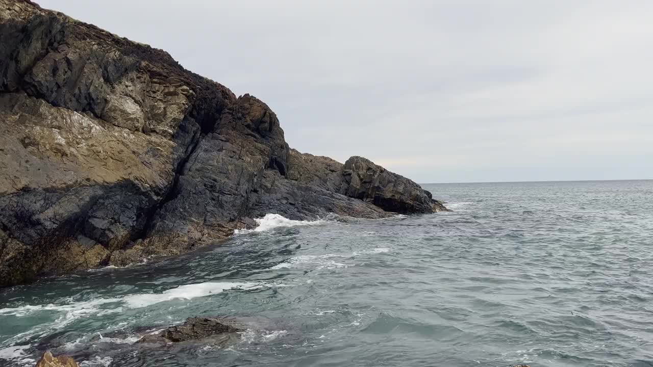 下雨天海岸岬和海浪涌动的景象。视频素材