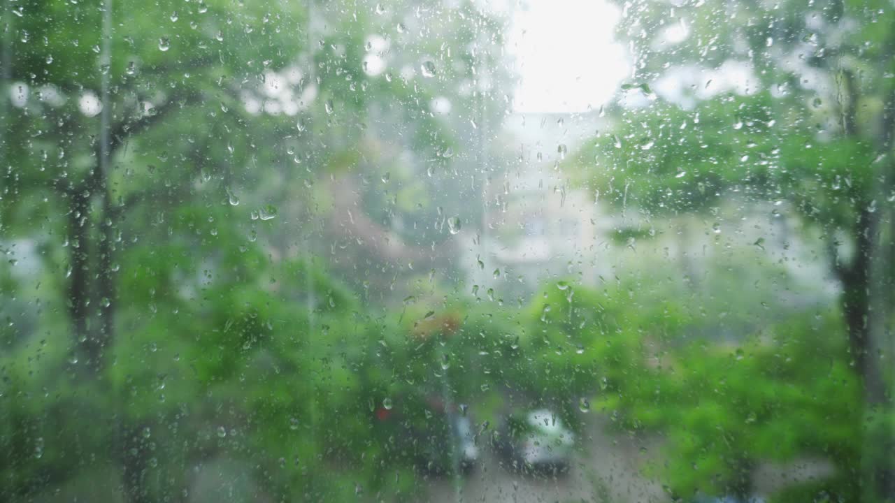 窗外的雨天。水滴在玻璃上流动。秋天的背景。视频素材